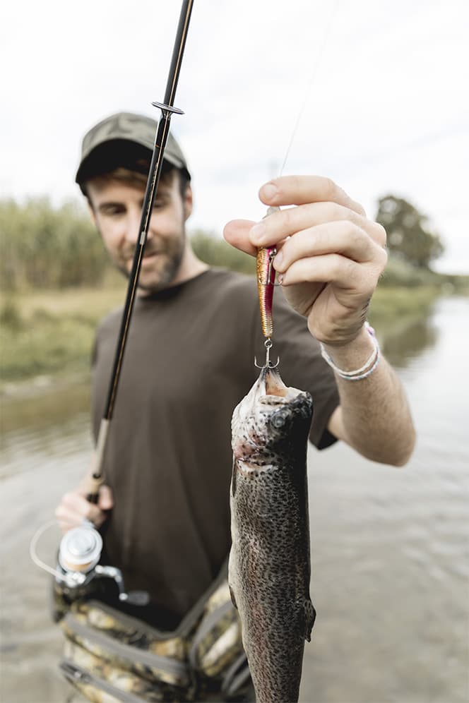 pêche en rivière homme qui a pêcher un poisson