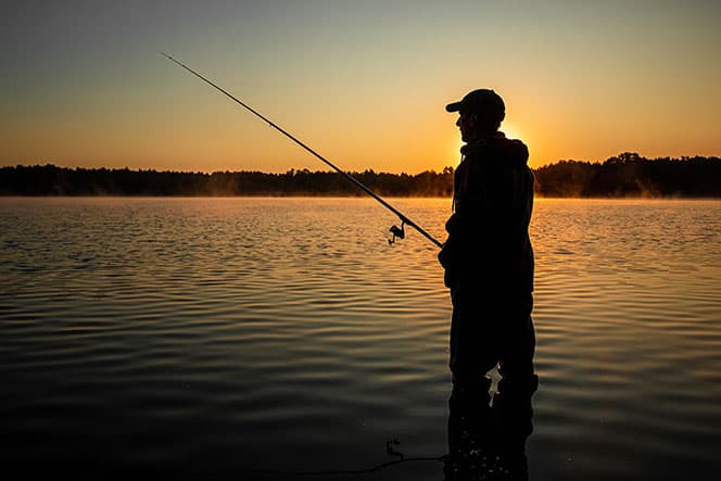 pecheur avec sa canne à peche la nuit